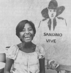 A young Nicaraguan women standing next to an example of a Sandino graffiti piece.